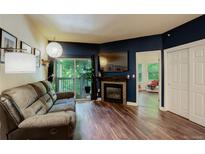 Comfortable living room with a fireplace, sliding glass door, and modern lighting at 2430 W 82Nd Pl # 2F, Westminster, CO 80031