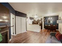 Bright, open living area featuring wood floors, a decorative fireplace, and seamless flow to the dining area at 2430 W 82Nd Pl # 2F, Westminster, CO 80031