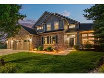 Charming two-story home features a stone facade, well-manicured lawn, and attached three car garage at 3041 Starling Ct, Castle Rock, CO 80109