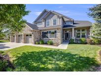 Charming two-story home with stone accents, manicured lawn, and three-car garage for ample parking at 3041 Starling Ct, Castle Rock, CO 80109