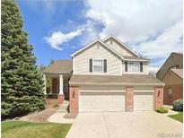 Charming two-story home featuring a two-car garage, neutral siding, and a well-manicured lawn at 2561 Cactus Bluff Pl, Highlands Ranch, CO 80129