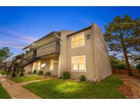 Two-story apartment building featuring balconies, green lawn, and beautiful landscaping at dusk at 7110 S Gaylord St # O7, Centennial, CO 80122