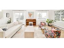 Bright living room featuring a piano, modern sofa, and floral armchairs at 3970 Longwood Ave, Boulder, CO 80305