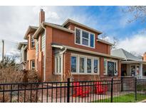 Charming brick home featuring a classic design with a welcoming front porch and a well-maintained front yard at 1053 S Washington St, Denver, CO 80209