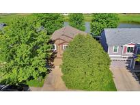 Charming home with well-maintained yard, mature trees, and a view of the lake at 293 Wagonwheel Dr, Fort Lupton, CO 80621
