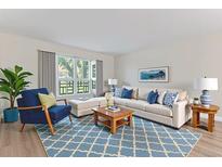 Bright living room with stylish blue accents and a large window overlooking the yard at 620 S Alton Way # 5B, Denver, CO 80247