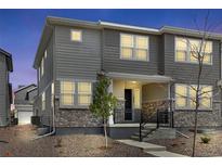 Charming townhome showcases stone accents, a welcoming front porch and professionally landscaped yard at 1422 Hudson Pl, Longmont, CO 80501