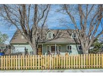 Charming home with a welcoming front porch and picket fence, framed by mature trees at 1065 6Th St, Berthoud, CO 80513