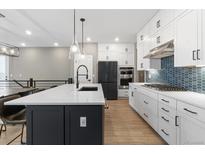 Modern kitchen featuring an island with a sink and stainless steel appliances and lighting at 17233 W 93Rd Pl, Arvada, CO 80007