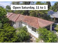 Charming single-story home featuring a red tile roof and lush landscaping, inviting curb appeal at 6235 E 6Th Avenue Pkwy, Denver, CO 80220