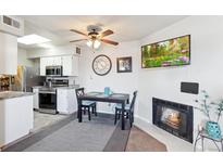 Inviting dining area features a fireplace and modern ceiling fan at 1845 Kendall St # 325D, Denver, CO 80214