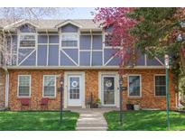 Charming townhome with brick facade, blue siding, well-maintained lawn, and a lovely tree at 12920 W 24Th Pl, Golden, CO 80401