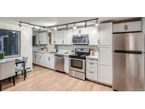 Updated kitchen with white cabinets, stainless steel appliances, and quartz countertops at 155 S Pennsylvania St # 101, Denver, CO 80209
