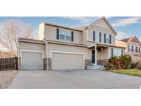 Charming two-story home featuring a three-car garage, landscaped yard, and classic architectural details at 10049 Granby Dr, Commerce City, CO 80022
