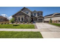 Beautiful two-story home with stone accents, well-kept lawn, and landscaped front yard enhancing its appeal at 12953 Reata Ridge Dr, Parker, CO 80134