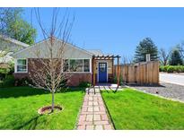 Charming brick home with a blue door and a pergola leading to the entrance at 2301 E Yale Ave, Denver, CO 80210