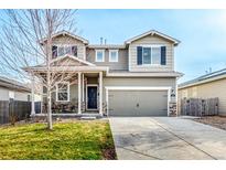 Inviting two-story home featuring a covered front porch and attached two-car garage at 574 Solano Dr, Brighton, CO 80603