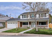 Charming two-story home with brick accents, a covered porch, and a well-manicured lawn at 7343 S Ivy Way, Centennial, CO 80112