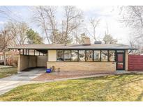 Charming single-story home featuring brick exterior, covered carport, and expansive windows at 3050 S Marion St, Englewood, CO 80113