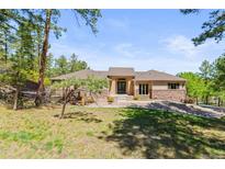 Charming home featuring a beautiful front yard with mature trees and a well-maintained lawn at 1988 Lake Dr, Larkspur, CO 80118