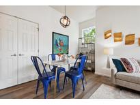 Bright dining area featuring a marble table, blue chairs, and modern lighting fixture at 2708 Syracuse St # 109, Denver, CO 80238