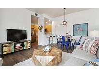 Inviting living space featuring an open layout to the kitchen and dining, plus stylish decor and hardwood floors at 2708 Syracuse St # 109, Denver, CO 80238