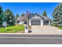 Charming exterior features a three-car garage, lush lawn, and mature trees at 44 Spyglass Dr, Littleton, CO 80123
