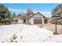 Two-story home with a snow-covered front yard, attached three-car garage, and updated exterior at 44 Spyglass Dr, Littleton, CO 80123