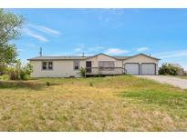 Charming single-story home with a two car garage, inviting porch, and ample front yard space at 554 E Pleasant Ave, Byers, CO 80103