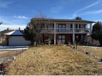 Charming two-story home with brick and siding exterior and a lovely covered balcony, perfect for relaxing outdoors at 8722 S Balsam St, Littleton, CO 80128