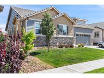 Charming home with manicured lawn and mature landscaping, creating appealing curb appeal at 15565 E 115Th Ave, Commerce City, CO 80022