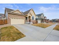 Charming two-story home with stone accents, a two-car garage, and well-maintained landscaping at 10256 Olathe Way, Commerce City, CO 80022