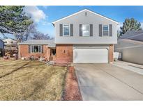 Charming two-story home with a brick facade and a well-maintained front yard at 8081 Johnson St, Arvada, CO 80005