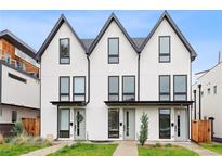 Modern townhouse exterior showcasing a clean, white facade with black trim and inviting front entrances at 1308 Stuart St, Denver, CO 80204