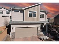 Beautiful two-story home with modern design, gray siding, and a two-car garage in a suburban neighborhood at 10232 Yampa Ct, Commerce City, CO 80022