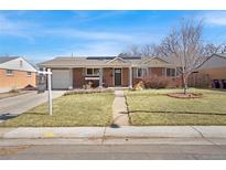 Charming brick home featuring a well-manicured front yard, attached garage, and lovely landscaping at 748 S Grape St, Denver, CO 80246