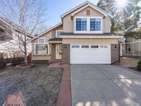 Charming two-story home features a two-car garage, manicured lawn, and inviting curb appeal at 9696 Pinebrook St, Highlands Ranch, CO 80130