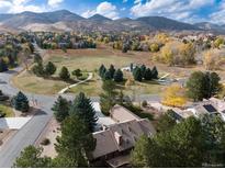Stunning aerial view of a home near mountains and open space with mature trees at 22 Mule Deer Trl, Littleton, CO 80127