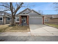 Charming home featuring a well-manicured lawn, mature trees, and a two-car garage at 9630 W La Salle Ave, Lakewood, CO 80227