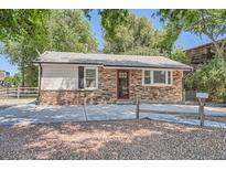 Charming single-story home featuring stone accents, modern siding, and a well-manicured front yard at 1390 Estes St, Lakewood, CO 80215