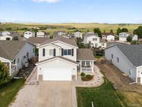 Charming two-story home featuring a covered porch, attached garage, and well-manicured landscaping at 7720 Brown Bear Way, Littleton, CO 80125