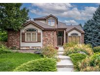 Charming two-story brick home with a landscaped front yard and inviting entrance at 8316 Green Island Cir, Lone Tree, CO 80124