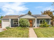Charming single-story home with blue siding, solar panels, a well-manicured lawn, and a welcoming front porch at 3202 S Dahlia St, Denver, CO 80222
