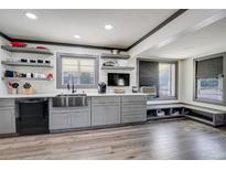 Modern kitchen featuring stainless steel sink, gray cabinets, open shelves, and wood-look flooring at 2226 Fulton St, Aurora, CO 80010