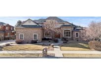 Beautiful stone home featuring a manicured front lawn and charming architectural details at 1313 Jade Ln, Longmont, CO 80504