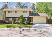 Charming two-story home featuring a well-maintained lawn, mature trees, and an attached two-car garage at 8484 E Radcliff Ave, Denver, CO 80237