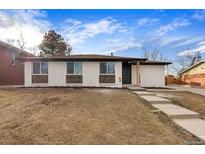 Charming single-story home with white painted brick, wood detail, and well-maintained landscaping at 8051 Clarkson Ct, Denver, CO 80229
