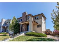 Inviting two-story home featuring stone accents, manicured lawn, and a welcoming front entrance at 10152 Southlawn Cir, Commerce City, CO 80022