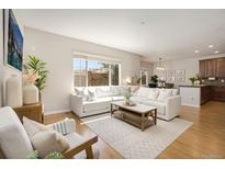 Inviting living room with large windows and a comfortable sectional couch, perfect for relaxing and entertaining at 11886 E Fair Ave, Greenwood Village, CO 80111