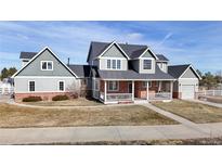 Charming two-story home featuring a welcoming front porch and a well-manicured lawn at 41402 Country Rose Cir, Parker, CO 80138